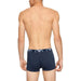 Man’s back wearing navy blue boxer briefs with Emporio Armani branded waistband