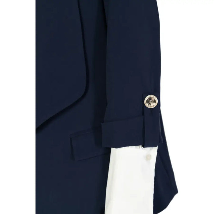 Navy blue blazer sleeve featuring a decorative silver button and white cuff detail