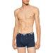 Navy blue boxer briefs with branded waistband on shirtless male torso by Emporio Armani