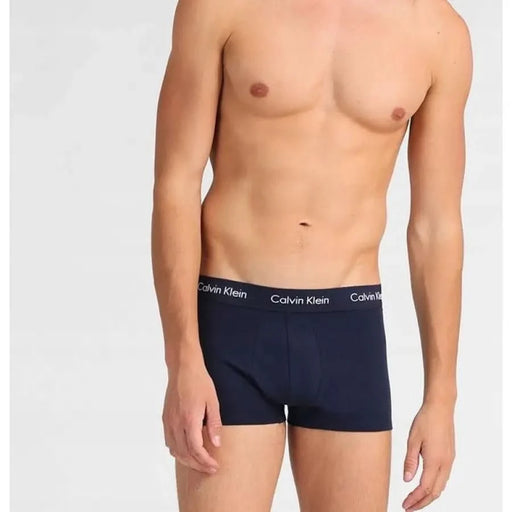 Male model showcasing Navy Blue Calvin Klein boxer briefs with a toned physique