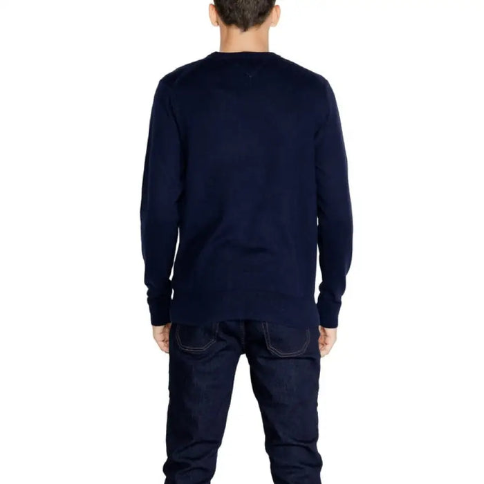 Navy blue long-sleeved crewneck sweater styled with dark jeans for men by Tommy Hilfiger