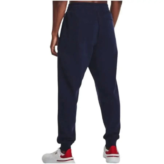 Navy blue Under Armour men trousers featuring elastic cuffs at the ankles