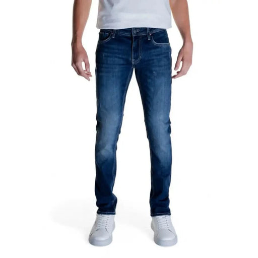 Pair of blue denim jeans worn with a white shirt and white sneakers by Antony Morato