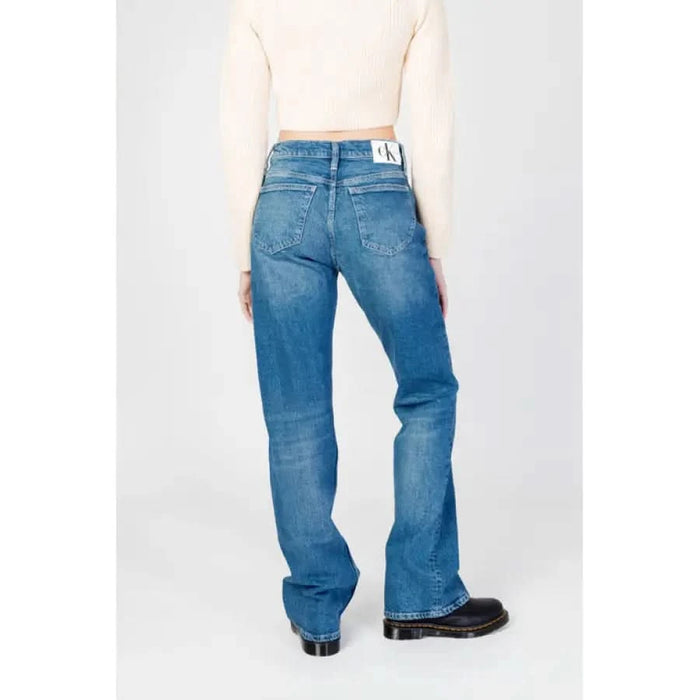 Woman in white top wearing Calvin Klein blue denim jeans