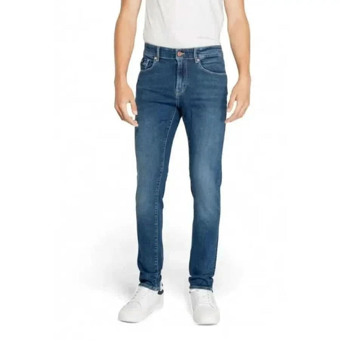 Pair of blue denim Gas Men Jeans worn with a white shirt and sneakers