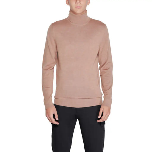 Pale pink turtleneck sweater showcased in Calvin Klein Men Knitwear collection