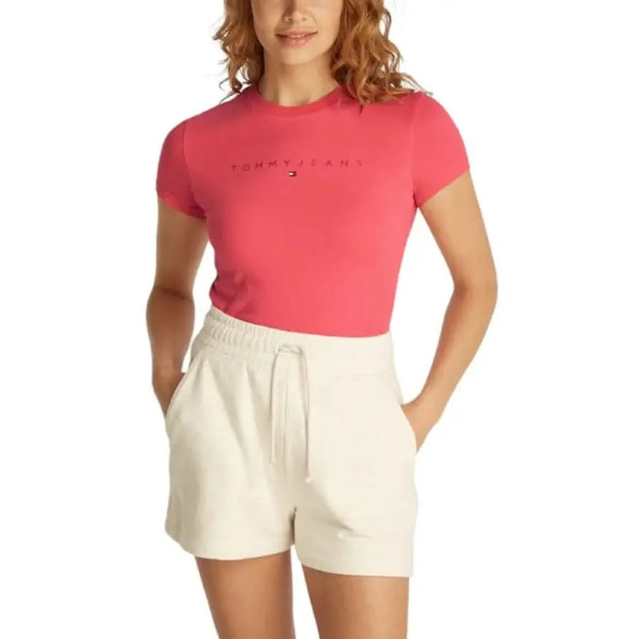 Pink Tommy Hilfiger t-shirt and white shorts on model with red wavy hair