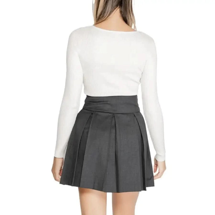 Pleated charcoal gray mini skirt with white long-sleeved top by Morgan De Toi