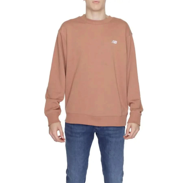 Salmon-colored crewneck sweatshirt with a small New Balance logo on chest for men