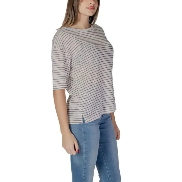 Striped white and gray half-sleeve top with blue jeans styled for B.Young women’s wear