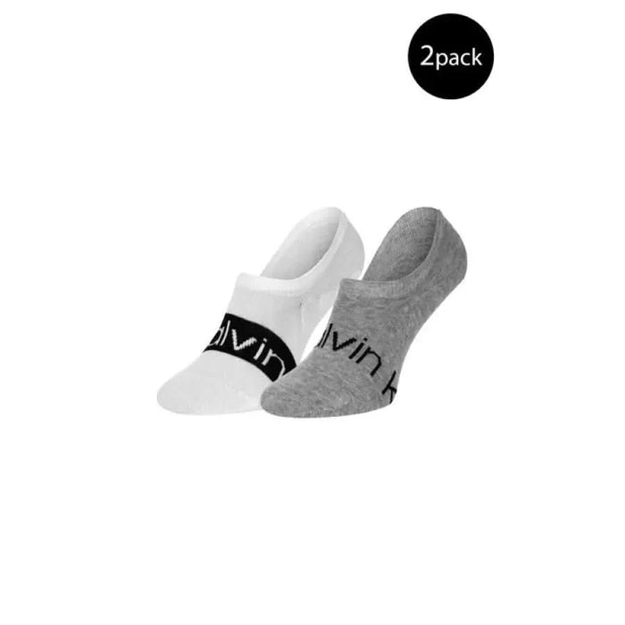 Two no-show Calvin Klein men’s socks, white and gray, with visible ‘Calvin’ branding