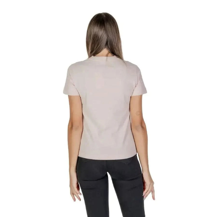 Back view of a beige short-sleeved t-shirt with black pants from Calvin Klein Jeans