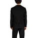 Back view of a man in Gianni Lupo black suit jacket and pants with dark curly hair