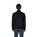 Back view of a model in a black turtleneck sweater and blue jeans from Boss Men Knitwear