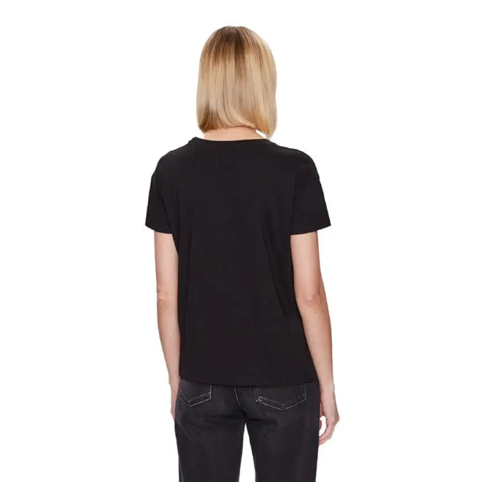 Back view of a person in an Armani Exchange Women T-Shirt and dark jeans