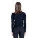 Back view of a person in Morgan De Toi Women Knitwear black long-sleeved top and dark pants