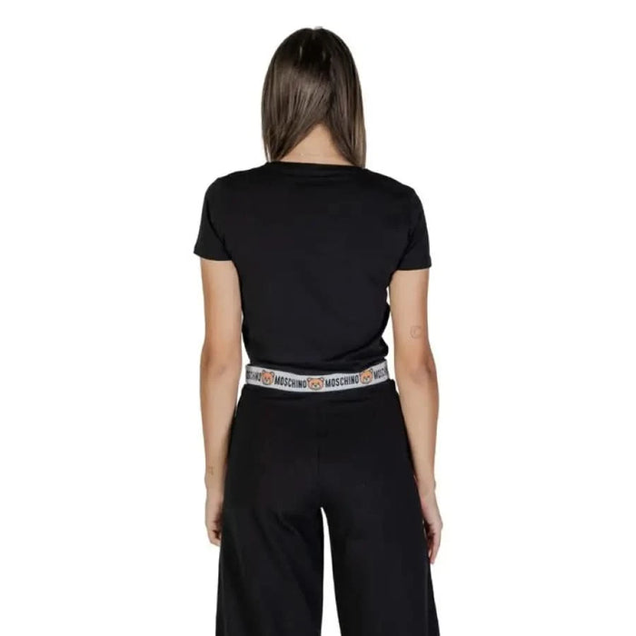 Back view of a person in a Moschino Underwear black t-shirt and elastic waistband pants