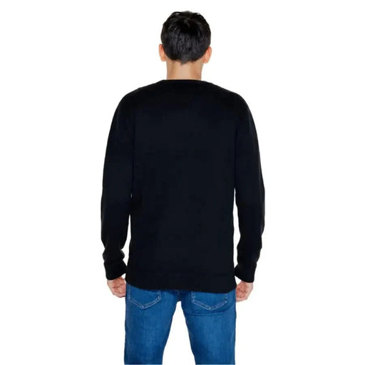 Back view of person in black sweater and blue jeans from Tommy Hilfiger Jeans