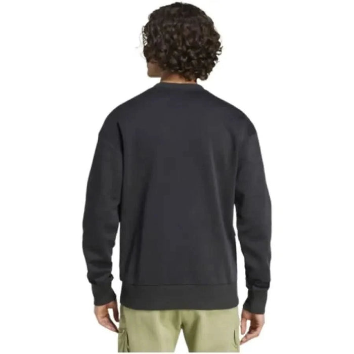 Back view of person in dark gray Adidas sweatshirt with curly hair