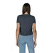 Back view of a person in a dark gray Calvin Klein Jeans t-shirt and light blue jeans