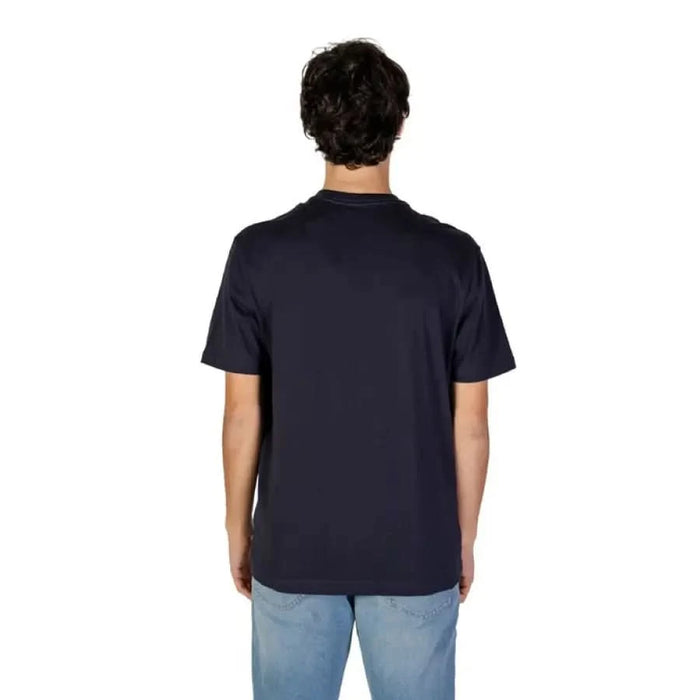 Back view of a person in a navy blue Gas Men T-Shirt and light blue jeans