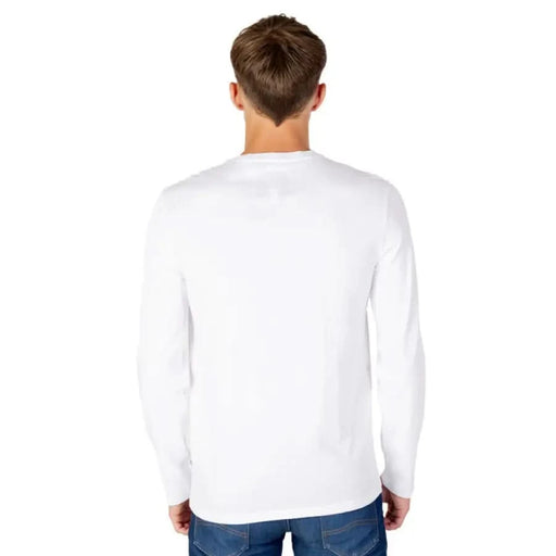 Back view of a person wearing Armani Exchange white long-sleeved shirt and blue jeans