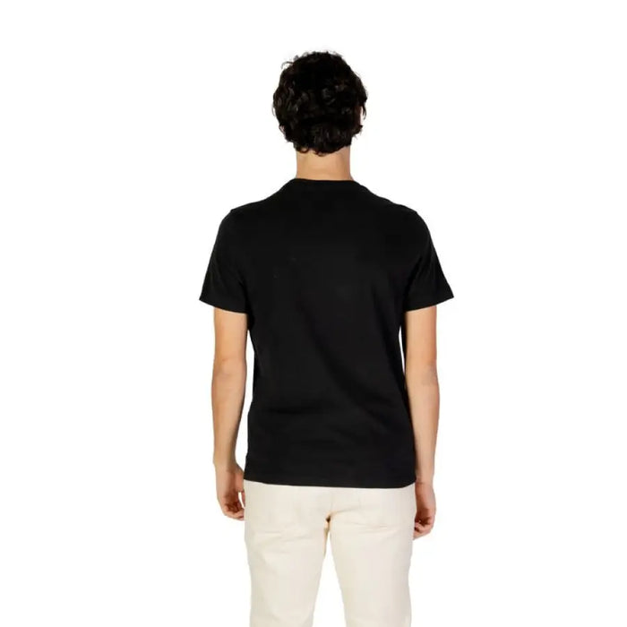 Back view of a man in a black t-shirt and cream pants from U.S. Polo Assn