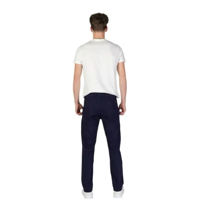 Back view of a person in a white t-shirt and navy blue trousers by Boss