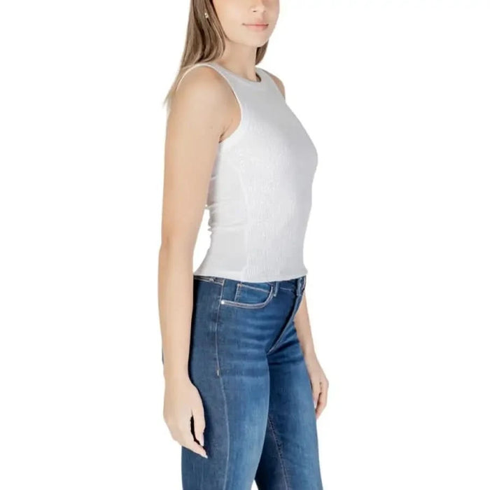 Side view of Guess Women’s White Paillette Tank Top with blue jeans