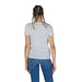 Back view of a model in a white Guess Women T-Shirt and blue jeans with braided hair