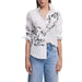 White button-down shirt with black swirl designs paired with light blue jeans for women