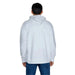 Person wearing a white hooded sweatshirt by Tommy Hilfiger Jeans, back view