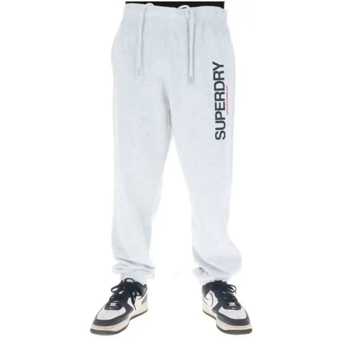 White Superdry sweatpants featuring vertical brand print on left leg