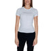 Woman wearing White Tommy Jeans T-shirt and dark pants from Tommy Hilfiger Jeans collection