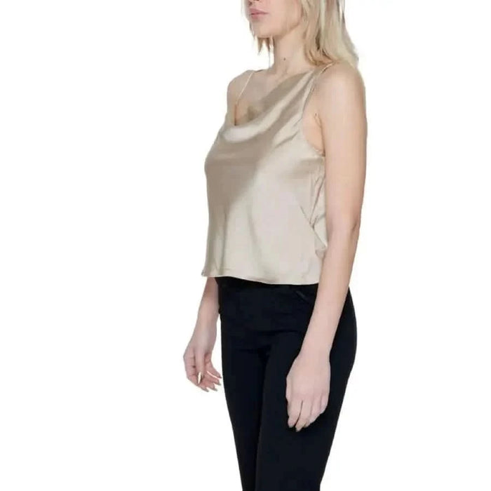 Woman in Only undershirt beige top and black pants showcasing urban city style fashion