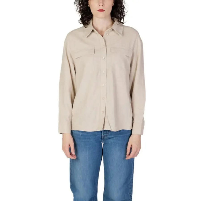 Woman in beige Only shirt and jeans showcasing urban city style fashion