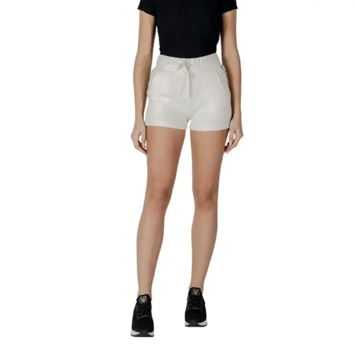 Woman modeling Guess Active Black Shorts with laces and beige top for stylish summer look