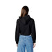 Woman wearing a black cropped hoodie and blue jeans from Calvin Klein Jeans Women Sweatshirts