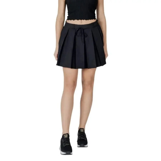 Woman modeling a black pleated skirt from the Red Lace Skirt Spring Summer Collection