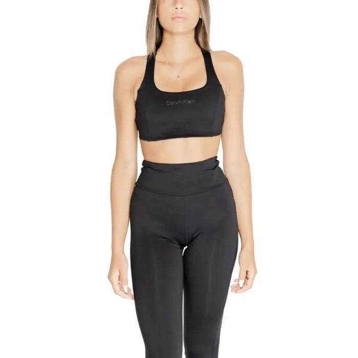 Woman in black sports bra and high-waisted leggings from Calvin Klein Sport collection