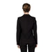 Woman modeling Sandro Ferrone women blazer in black suit and white shirt