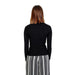 Woman in black sweater and striped pants from Only Women Knitwear, embodying urban city fashion