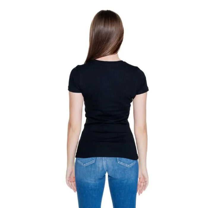 Woman in black t-shirt and blue jeans from behind - Guess Women T-Shirt