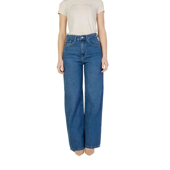 Woman in blue wide-leg jeans and beige t-shirt featuring Women’s Blue Plain Cotton Jeans