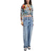 Woman in floral striped long-sleeve top and wide-leg jeans showcasing Desigual sweater