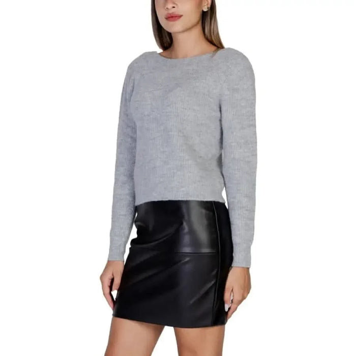 Woman in a gray sweater and black leather mini skirt from Morgan De Toi Women Knitwear