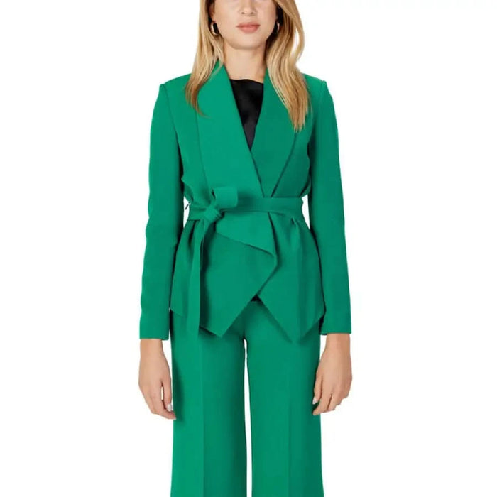 Woman in Sandro Ferrone green blazer with black top and pants - urban chic fashion