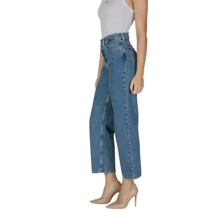 Woman in high-waisted blue jeans from Calvin Klein for Spring and Summer collection