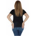 Woman with long blonde hair in black Champion T-Shirt and blue jeans, seen from behind