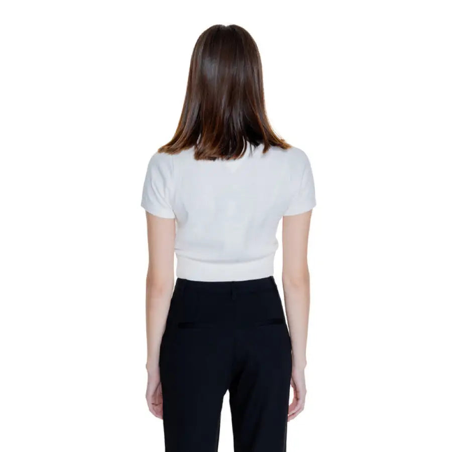 Woman in white t-shirt and black pants modeling Tommy Hilfiger Jeans Women Knitwear